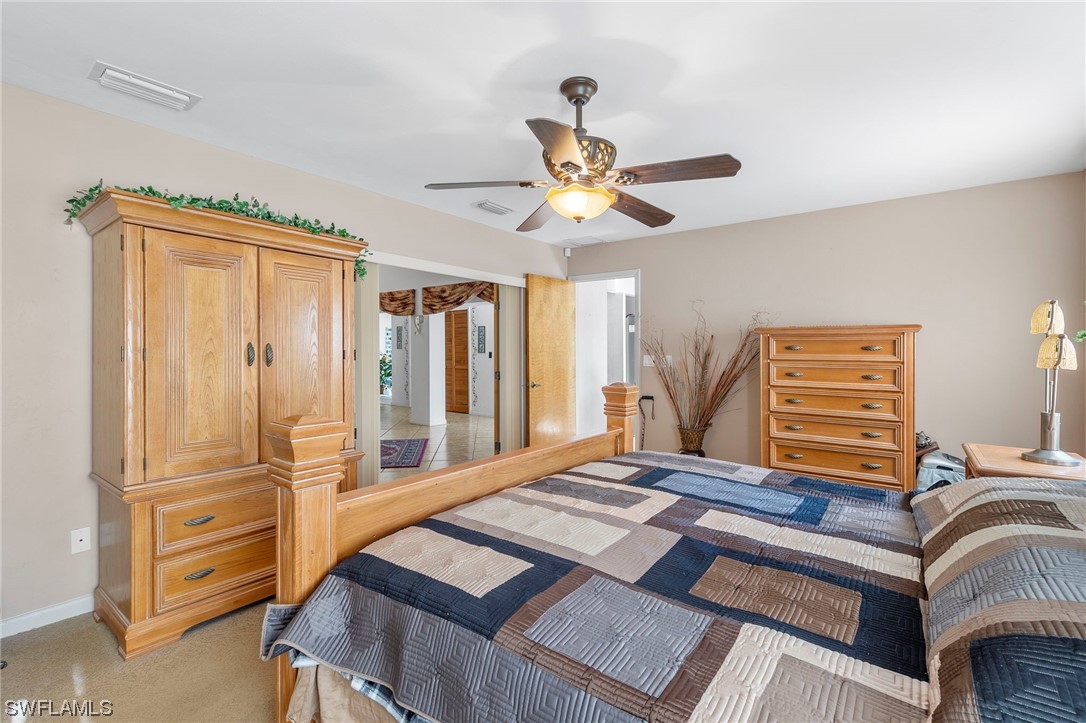 13751 River Road Fort Myers, FL 33905 - Photo 31 of 50 a bedroom with a bed and a chandelier