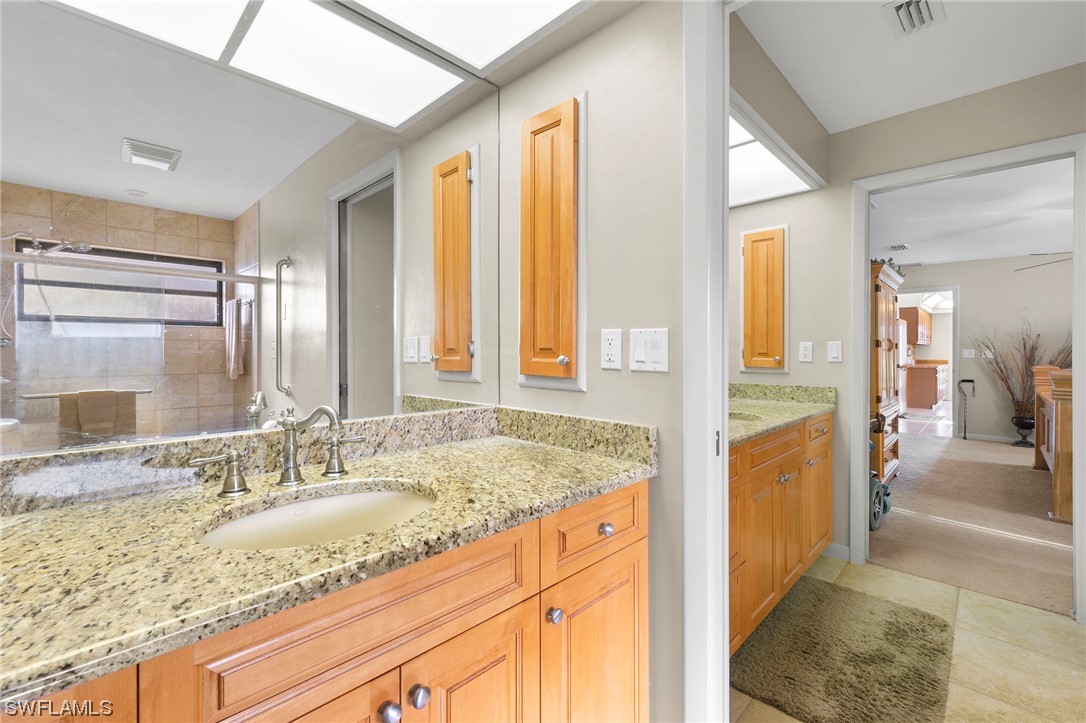 13751 River Road Fort Myers, FL 33905 - Photo 32 of 50 a en suite bathroom with a granite countertop sink and a mirror