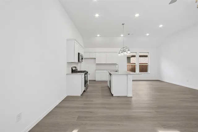 a view of kitchen with wooden floor and stainless steel appliances