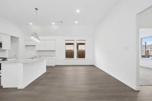 a large kitchen with kitchen island white cabinets and wooden floor