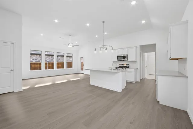 a kitchen with stainless steel appliances granite countertop a stove a sink and a refrigerator