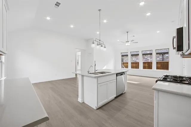 a kitchen with stainless steel appliances granite countertop a stove and a sink