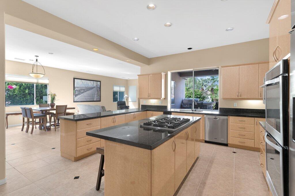 8 MacBeth Court Rancho Mirage, CA 92270 - Photo 12 of 46 a kitchen with granite countertop sink stove and refrigerator