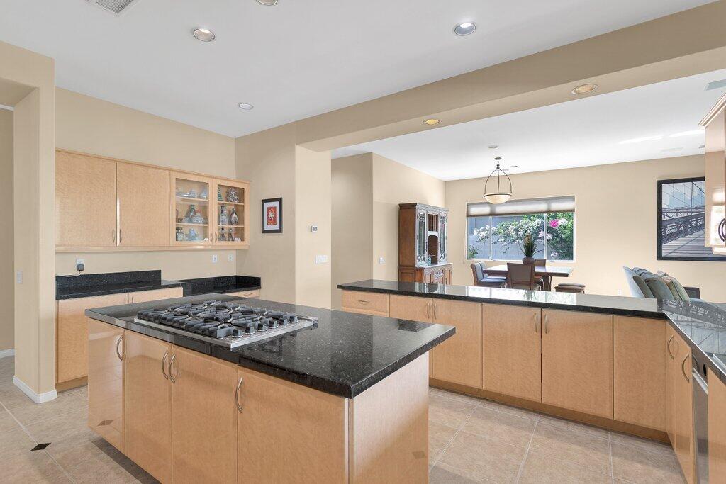 8 MacBeth Court Rancho Mirage, CA 92270 - Photo 13 of 46 a kitchen with a stove a sink a refrigerator and wooden cabinets