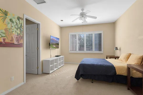 a spacious bedroom with a bed and a chandelier