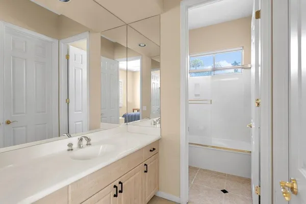 a bathroom with a shower sink and mirror