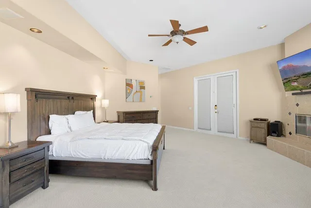 a bedroom with a bed a couch and a ceiling fan