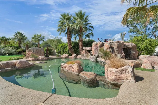 a view of a swimming pool with a patio and a yard