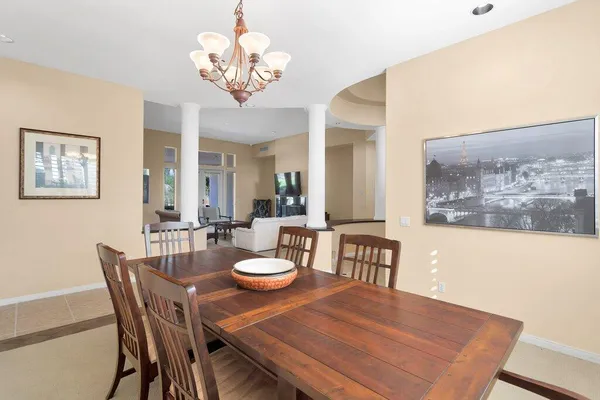 a view of a dining room with furniture a chandelier and wooden floor