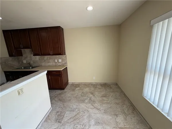 a kitchen with granite countertop a sink a stove and a microwave oven in a cabinets