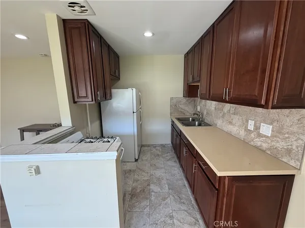 a kitchen with stainless steel appliances granite countertop a sink a stove and a refrigerator