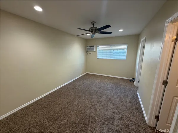 en empty room with windows and a ceiling fan