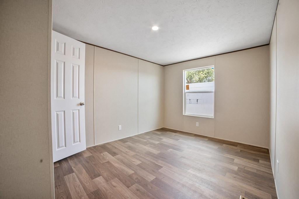 1023 Hopewell Road Bowie, TX 76230 - Photo 19 of 28 a view of an empty room with wooden floor
