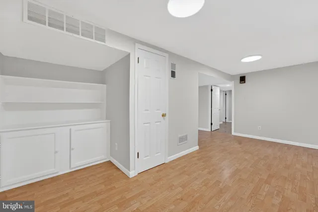 a view of an empty room with wooden floor