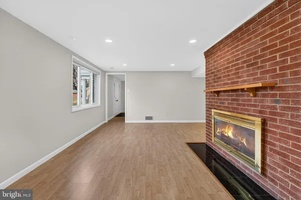a view of an empty room with a fireplace and a window
