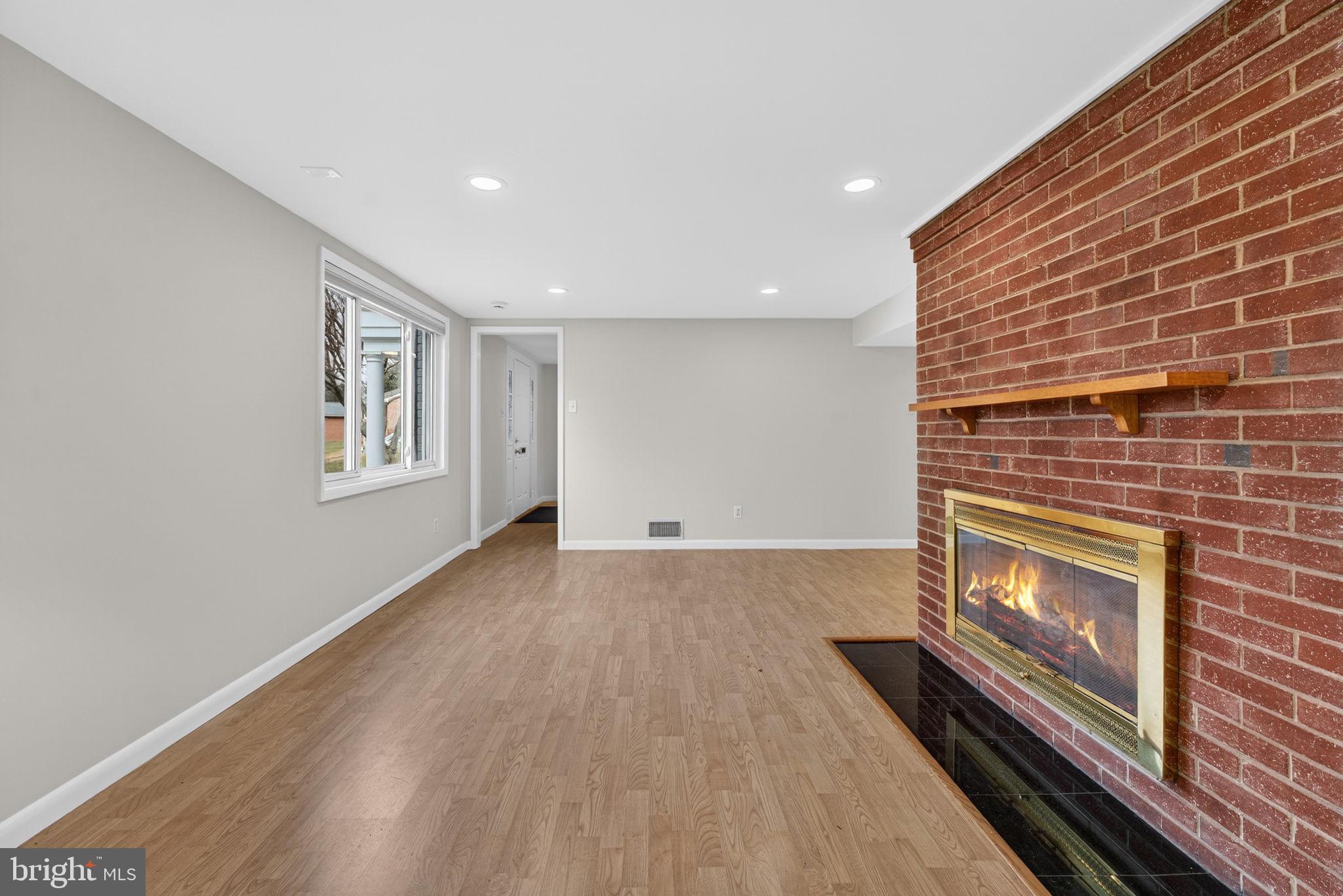 7507 Murillo Street Springfield, VA 22151 - Photo 13 of 44 a view of an empty room with wooden floor fire place and a refrigerator