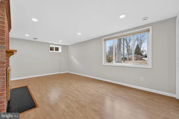 a view of an empty room with a fireplace and a window