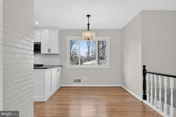 a view of empty room with wooden floor and fireplace
