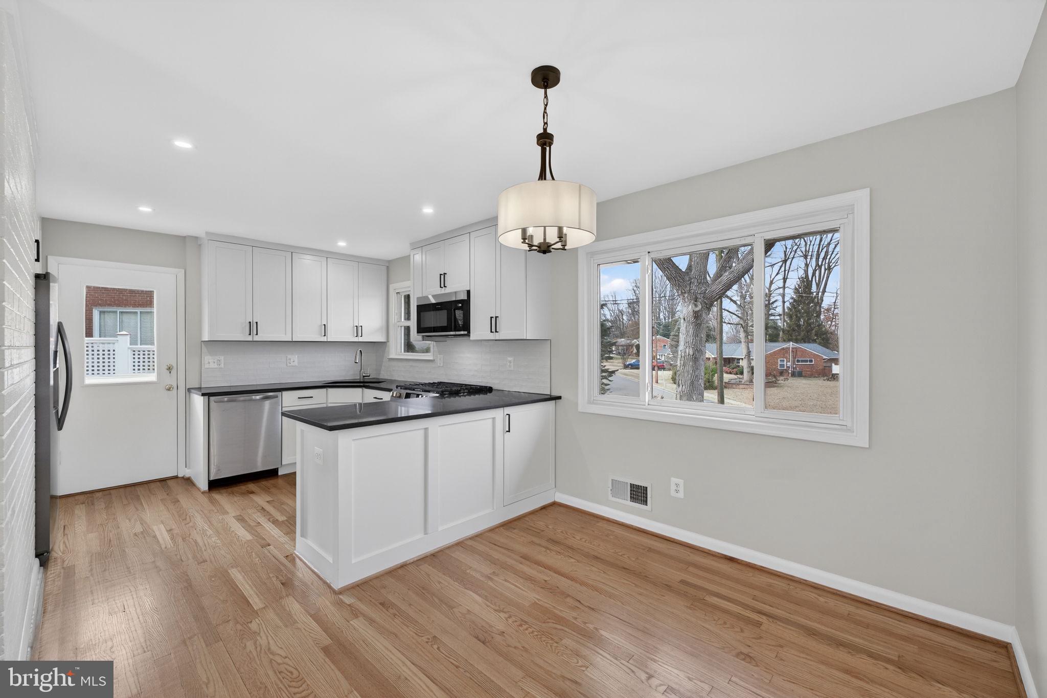 7507 Murillo Street Springfield, VA 22151 - Photo 20 of 44 a kitchen with granite countertop a stove a sink a refrigerator and a wooden floor