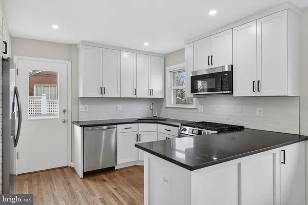 a kitchen with stainless steel appliances granite countertop a stove a sink and a window