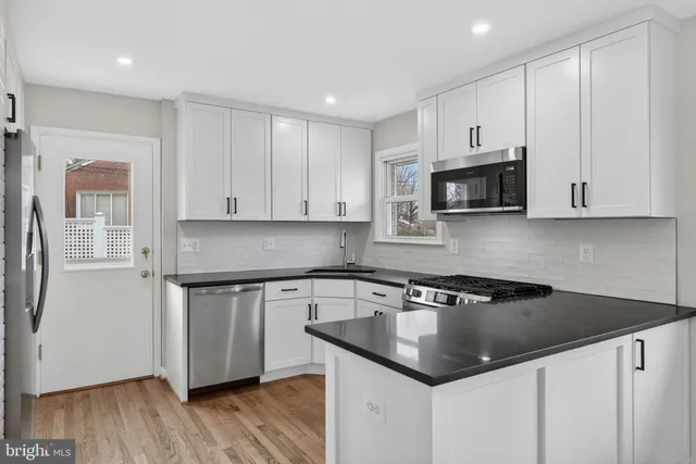 a kitchen with stainless steel appliances granite countertop a stove a sink and a window