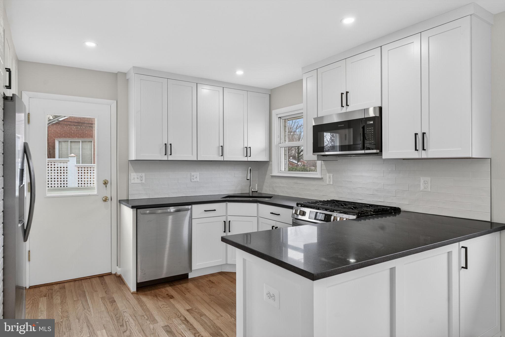 7507 Murillo Street Springfield, VA 22151 - Photo 21 of 44 a kitchen with stainless steel appliances granite countertop a sink a stove a microwave and cabinets