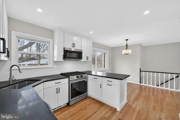 a kitchen with stainless steel appliances granite countertop a sink a stove a microwave and cabinets