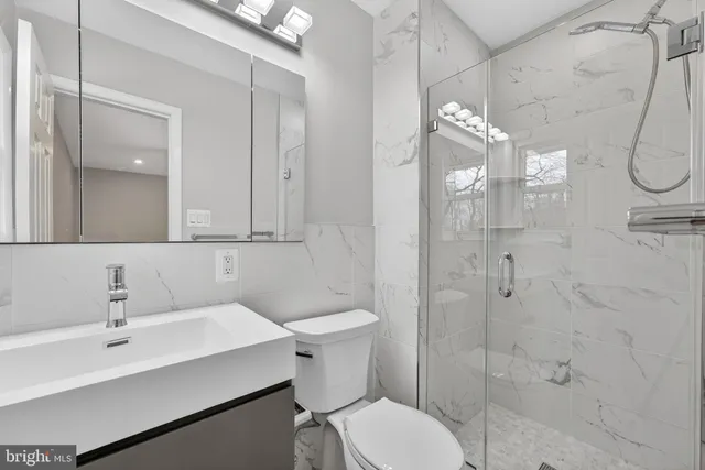 a view of an empty room with wooden floor and a ceiling fan