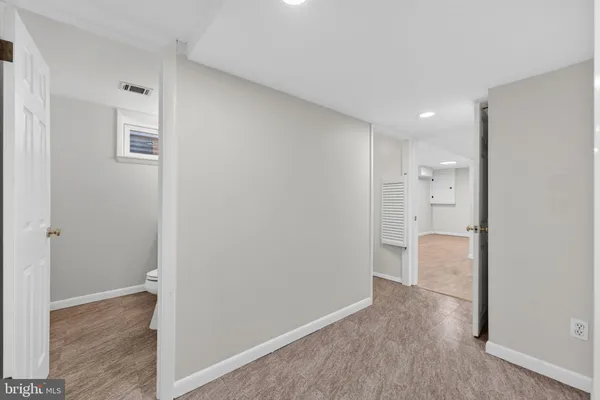 a view of a hallway with staircase and white walls