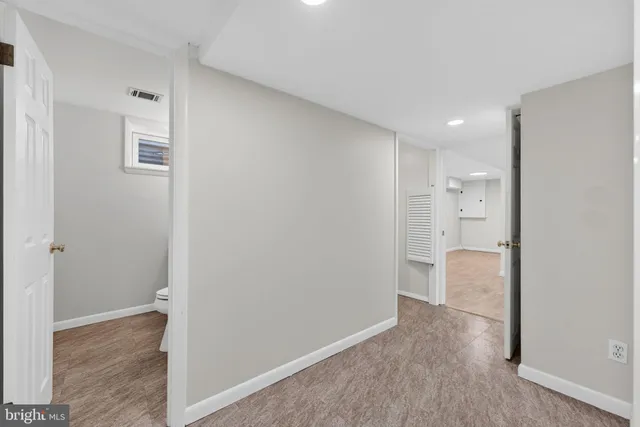 a view of a hallway with staircase and white walls