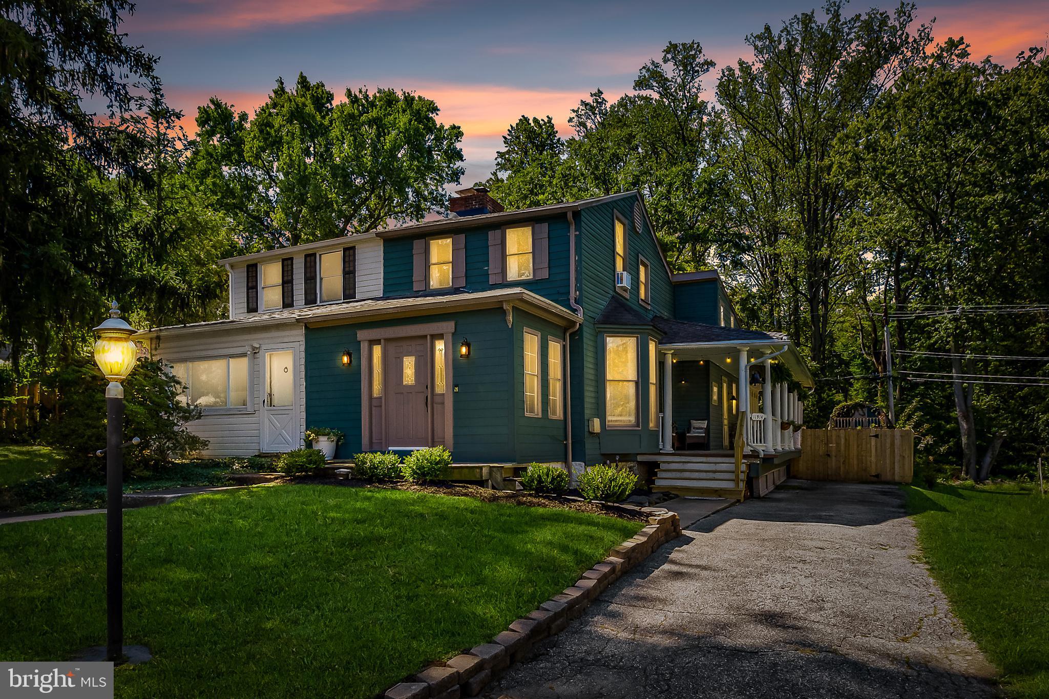 a front view of a house with a yard and trees