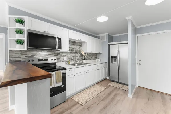 a kitchen with stainless steel appliances a stove microwave and refrigerator