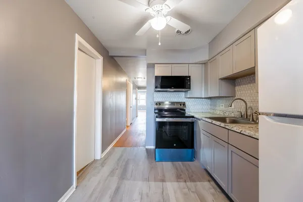 a kitchen with granite countertop stainless steel appliances and wooden floor