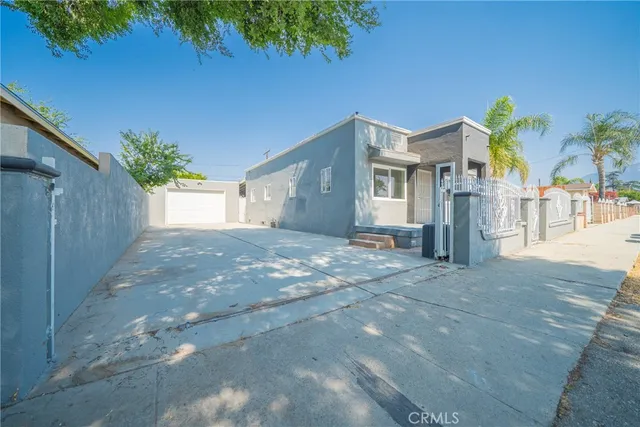 a view of a house with a yard and a tree