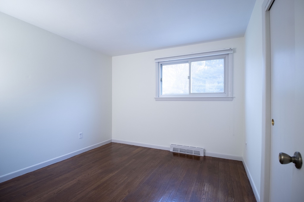 12 Johnson Road Sharon, MA 02067 - Photo 9 of 14 a view of an empty room with wooden floor and a window
