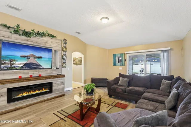 a living room with furniture a fireplace and a flat screen tv