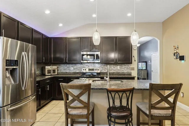 a kitchen with a table chairs refrigerator and microwave