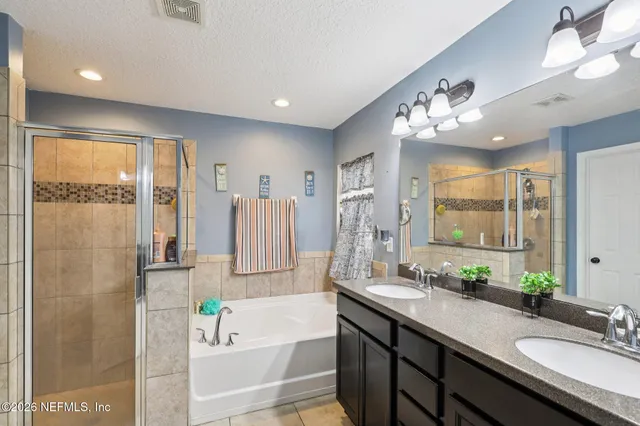 a spacious bathroom with a double vanity sink mirror and shower