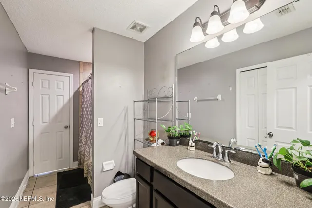 a bathroom with a granite countertop sink toilet a mirror a vanity and shower