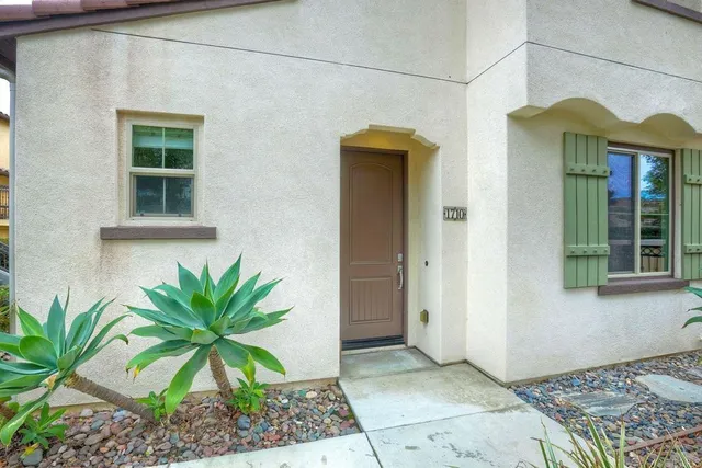 a house view with a potted plant in front of a door