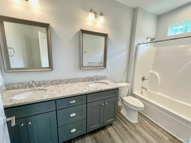 a bathroom with a granite countertop toilet sink and mirror