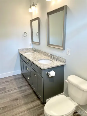 a bathroom with a granite countertop toilet sink and mirror