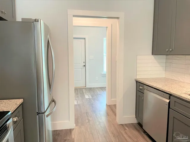 a view of hallway with wooden floor and electronic appliances