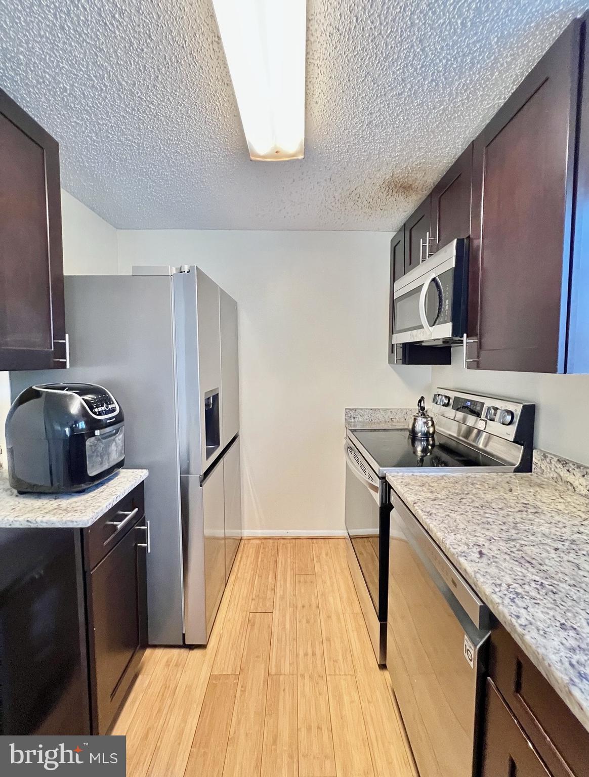 8679 Hickory Ridge Court Springfield, VA 22153 - Photo 4 of 23 a kitchen with a sink stove and refrigerator