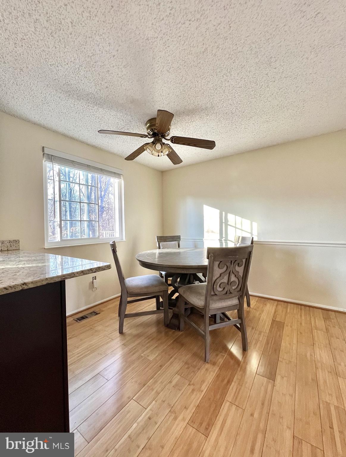 8679 Hickory Ridge Court Springfield, VA 22153 - Photo 6 of 23 a dining room with wooden floor and a ceiling fan