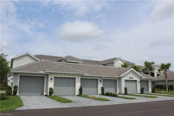 a front view of a house with a garden and garage