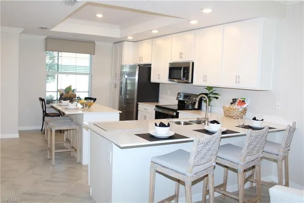 a kitchen with a dining table cabinets and refrigerator