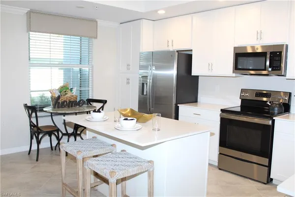a kitchen with a refrigerator and a stove top oven
