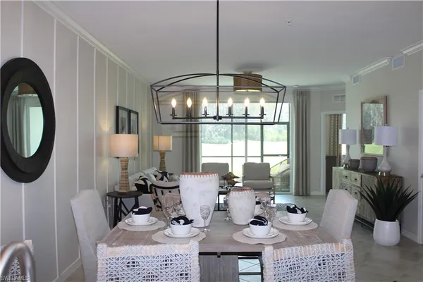 a dining room with furniture a chandelier and window