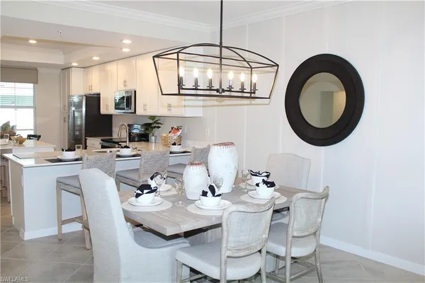 a dining room with wooden floor a chandelier a wooden table and chairs